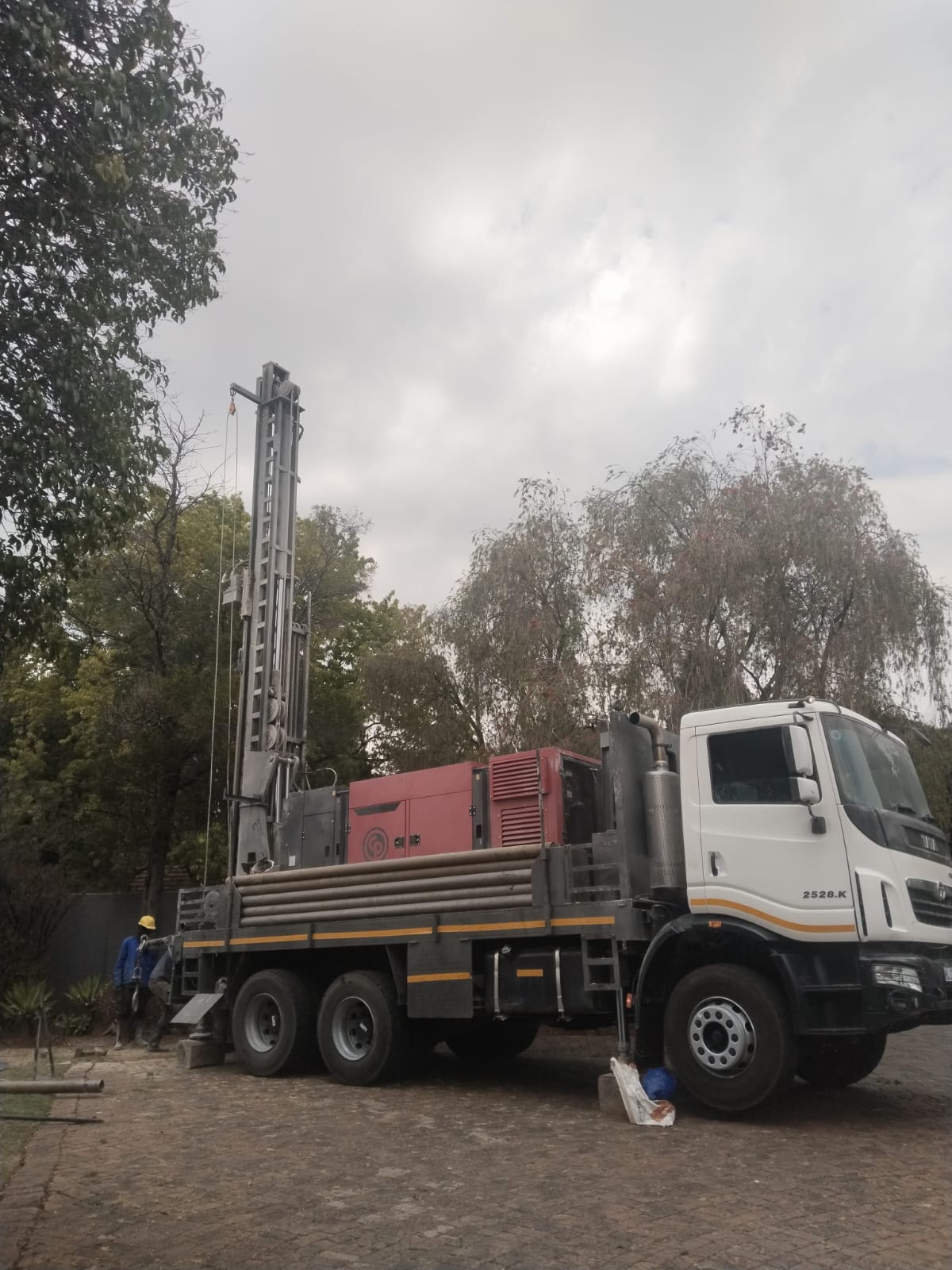 Drilling truck on site with pipes and generator